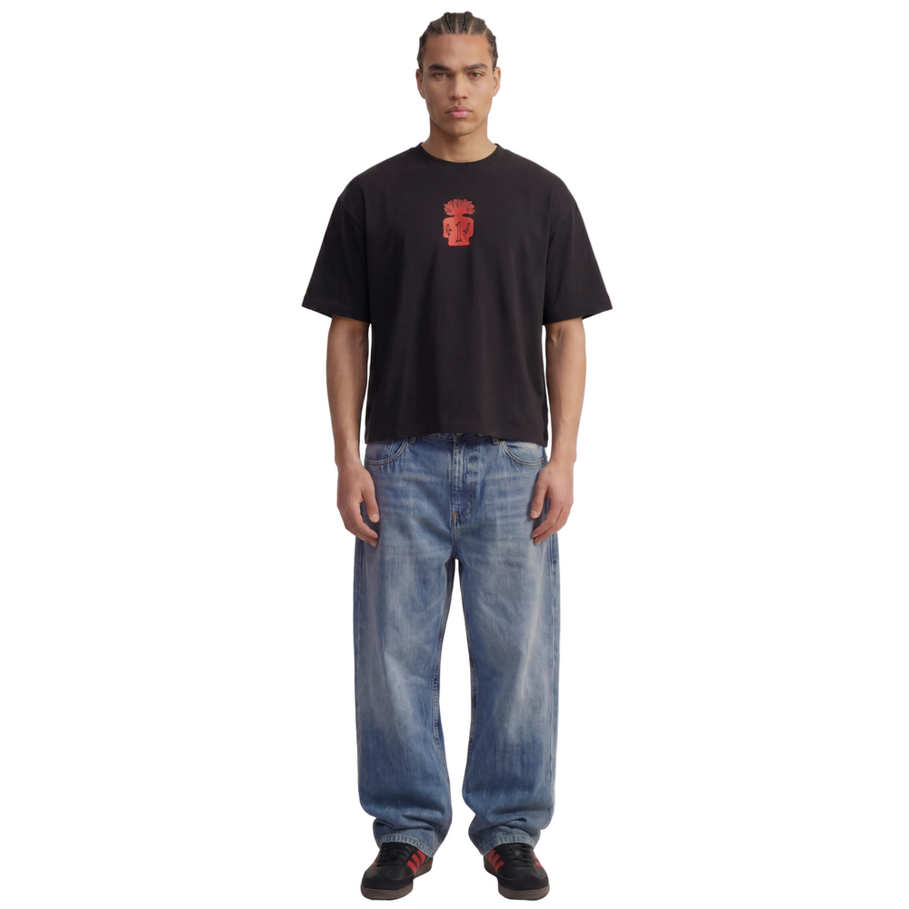 Person wearing a 1UBU black t-shirt with a red logo and blue jeans on a white background