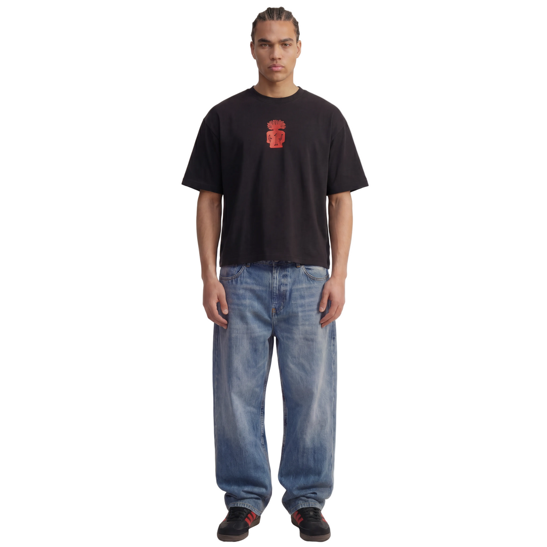 Person wearing a 1UBU black t-shirt with a red logo and blue jeans on a white background