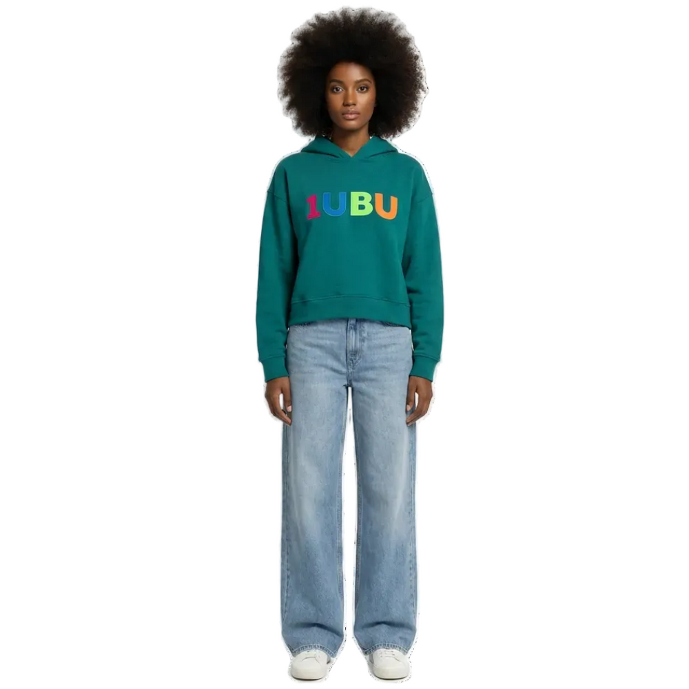 Person wearing a teal hoodie with colorful letters and light blue jeans on a white background