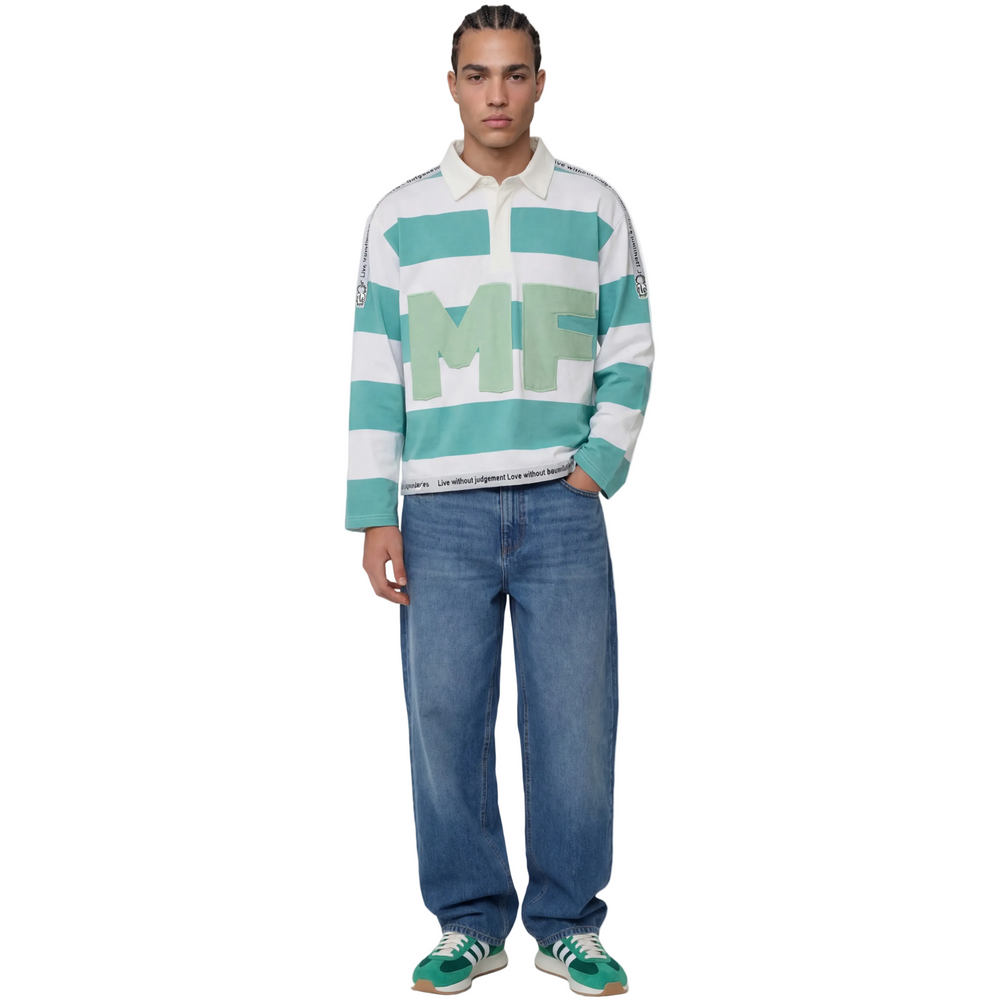 Person wearing a striped sweater with 'MF' letters and blue jeans on a white background