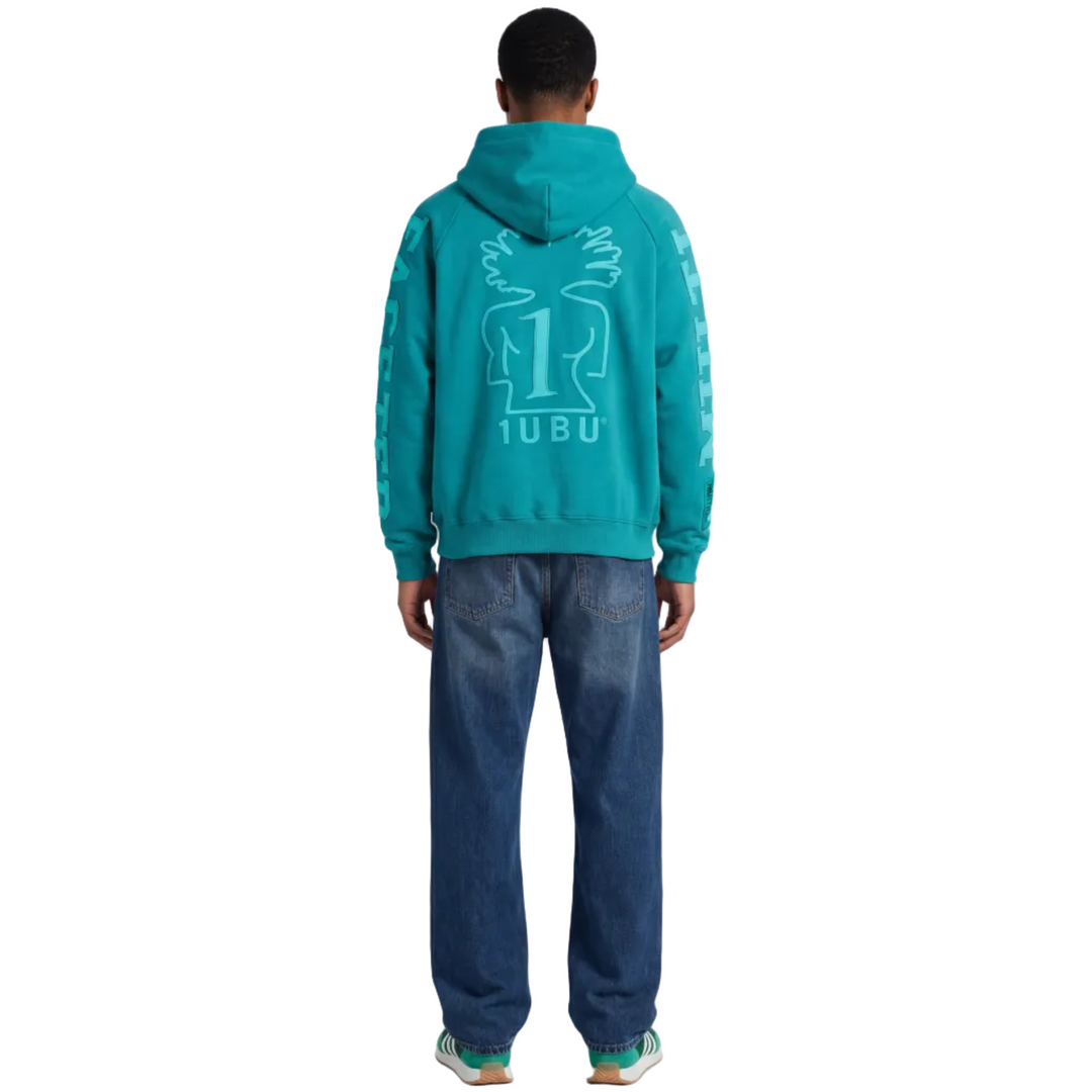 Person wearing a teal hoodie with a logo on the back, standing against a white background