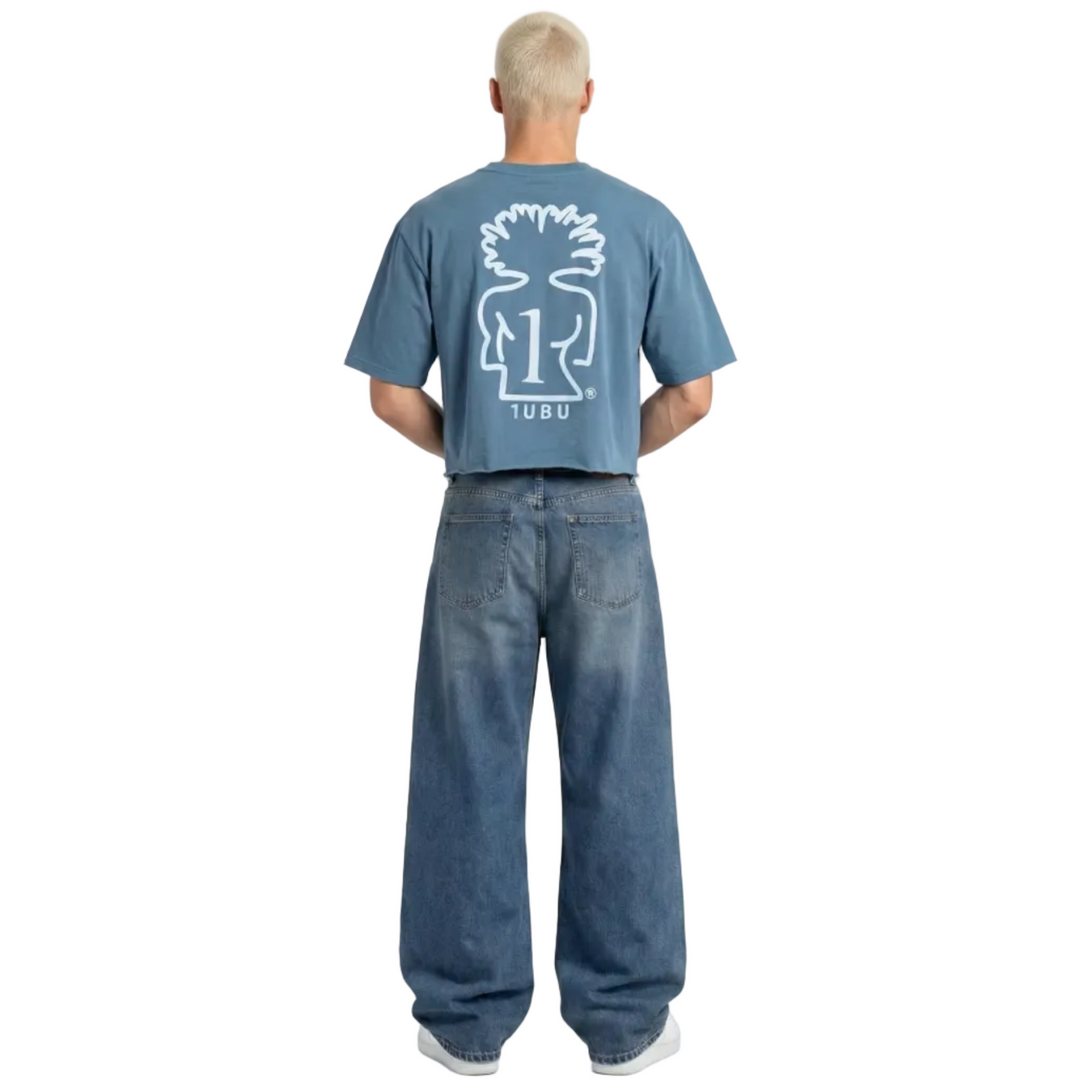 Person wearing a blue t-shirt with a logo and text, standing against a white background