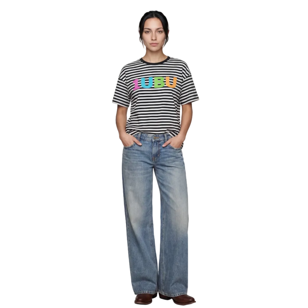 Person wearing a striped shirt with colorful text and blue jeans on a white background