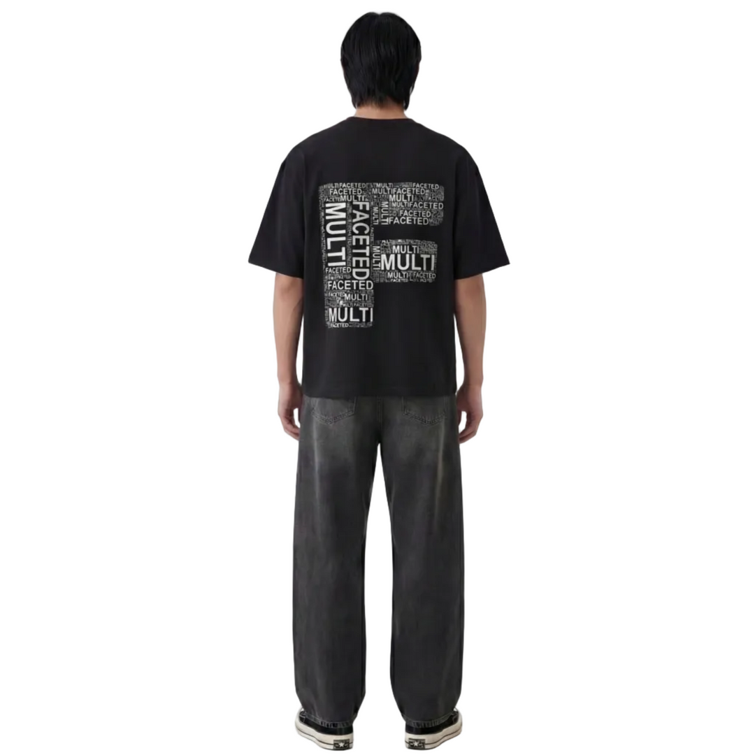 Person wearing a black t-shirt with text on the back, standing against a white background