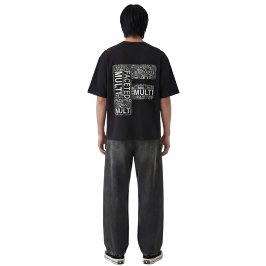 Person wearing a black t-shirt with text on the back, standing against a white background